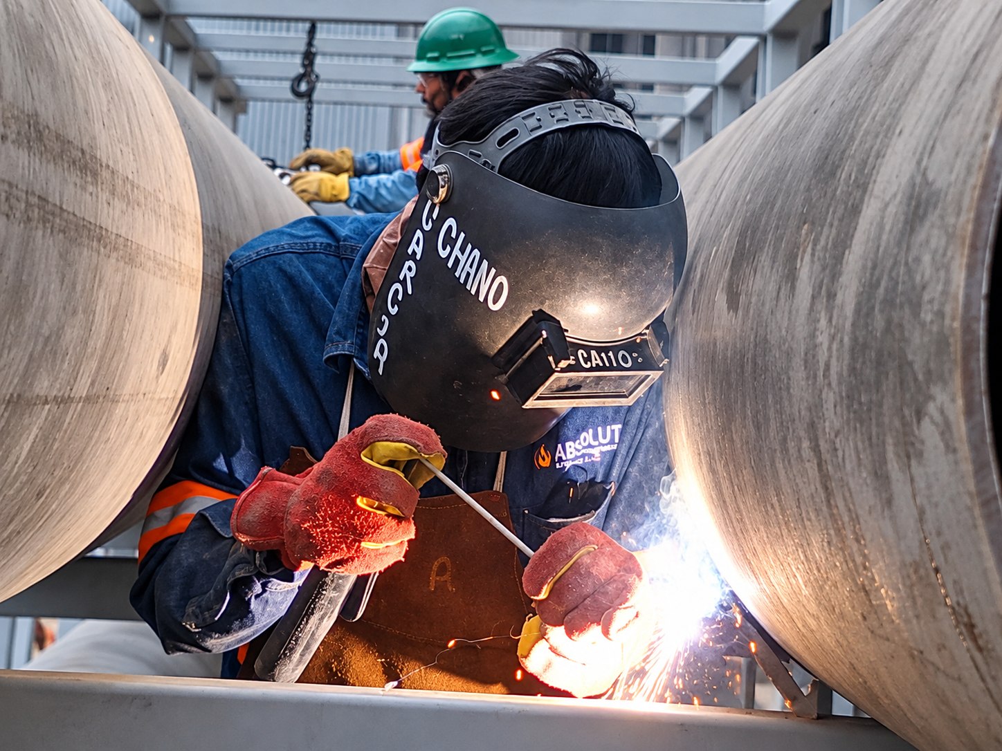 Técnico realizando trabajos de soldadura en tuberías industriales.