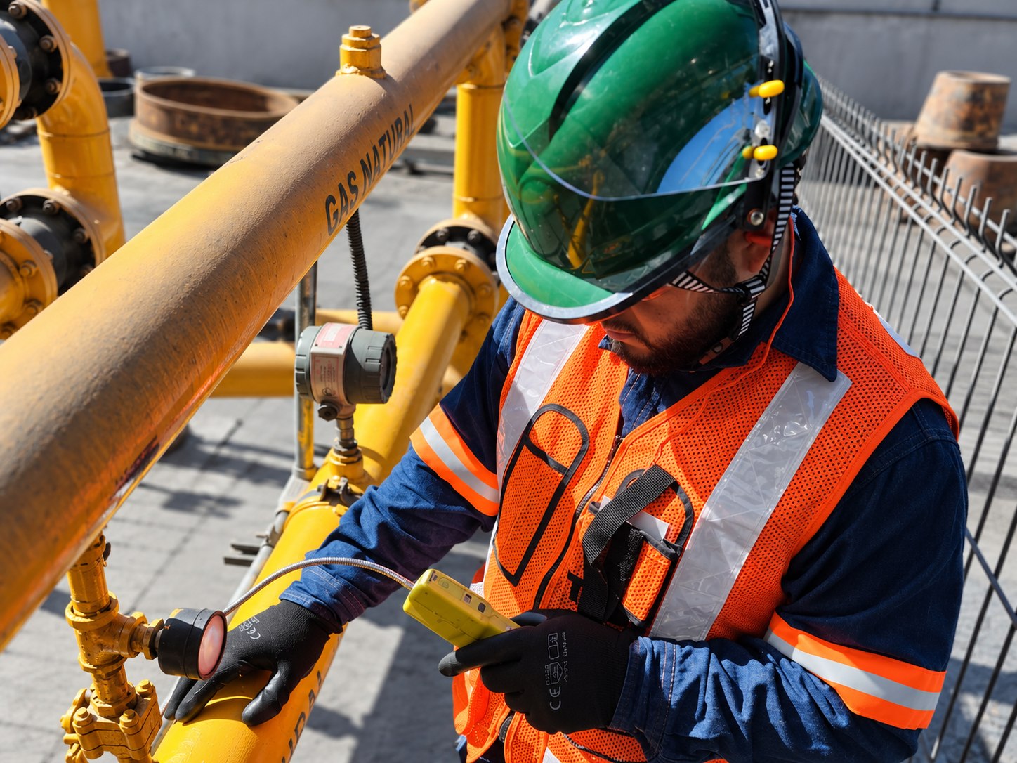 Técnico revisando tuberías con un detector portátil.